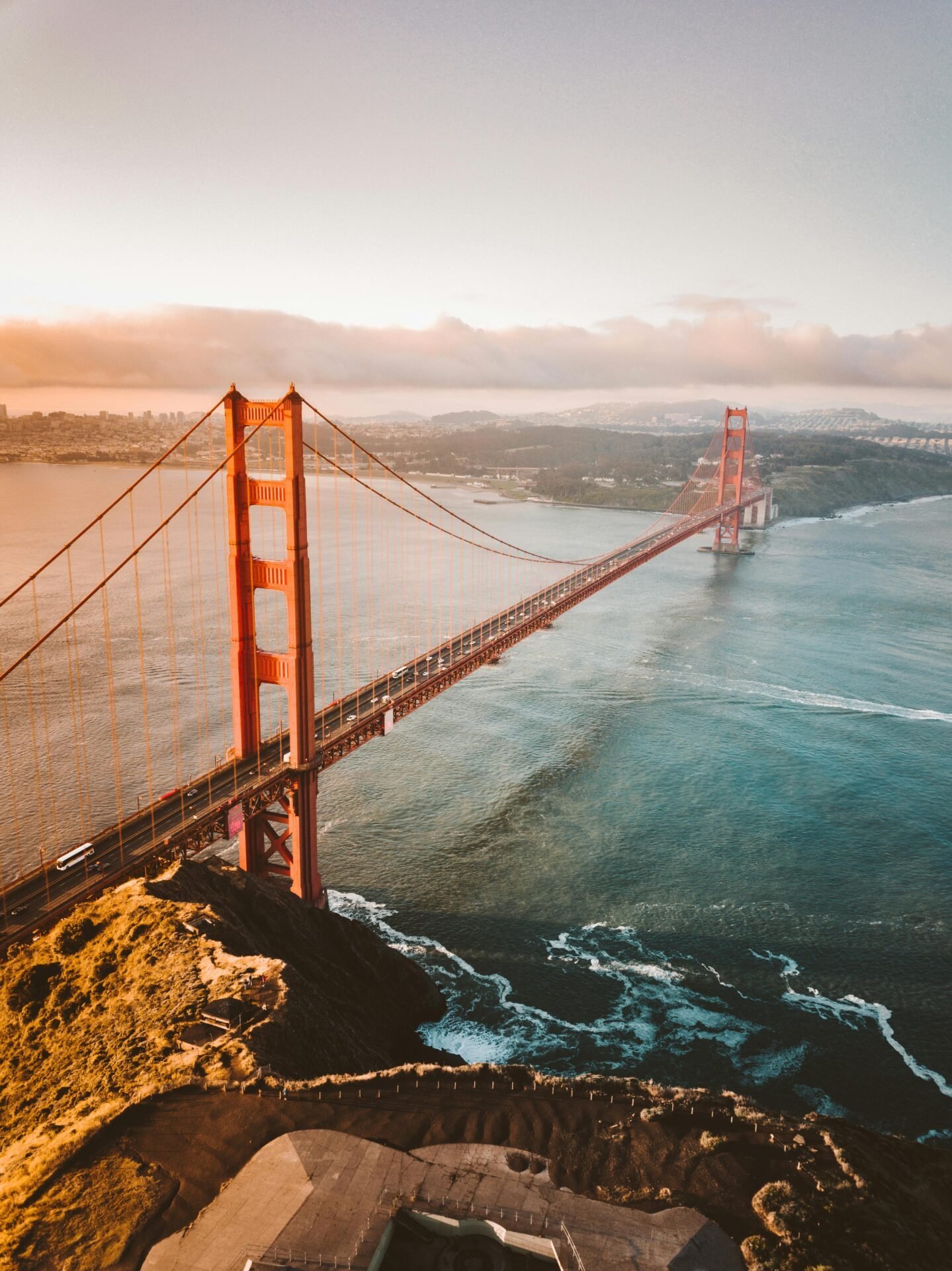 Luftaufnahme der Golden Gate Bridge, die die Arbeit in den USA bei Sonnenuntergang über dem blauen Wasser symbolisiert.
