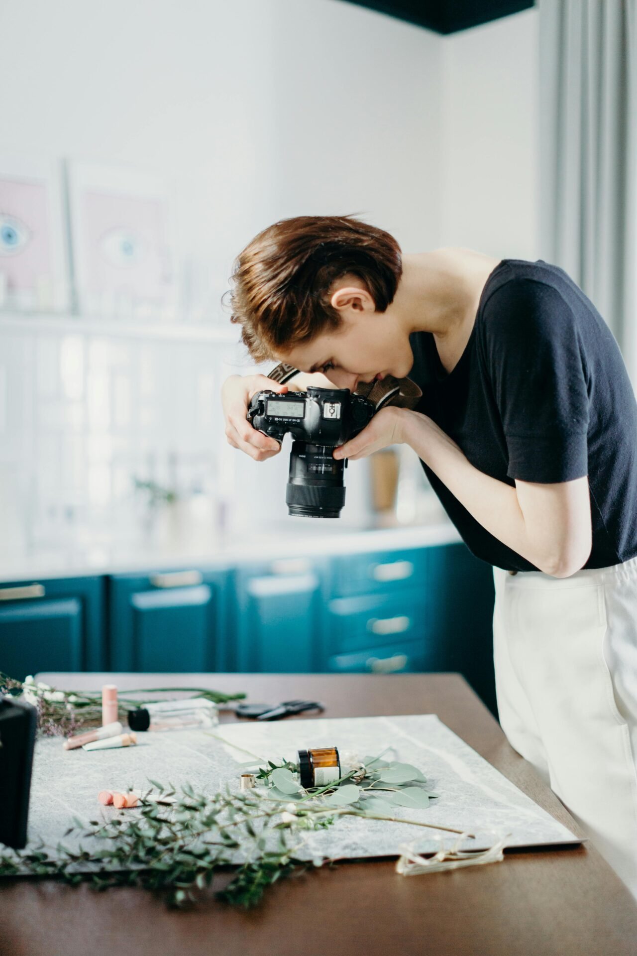 Person, die Objekte auf einem Tisch fotografiert und mit scharfem Geschäftssinn Details festhält.