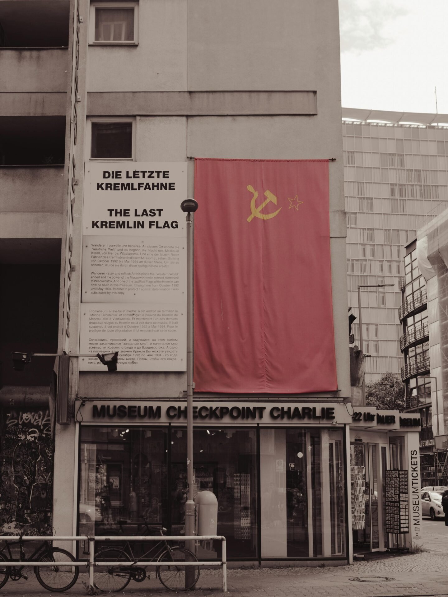 Eine sowjetische Flagge hängt über einem Schild des Museums Checkpoint Charlie, eine klassische Berliner Sehenswürdigkeit.