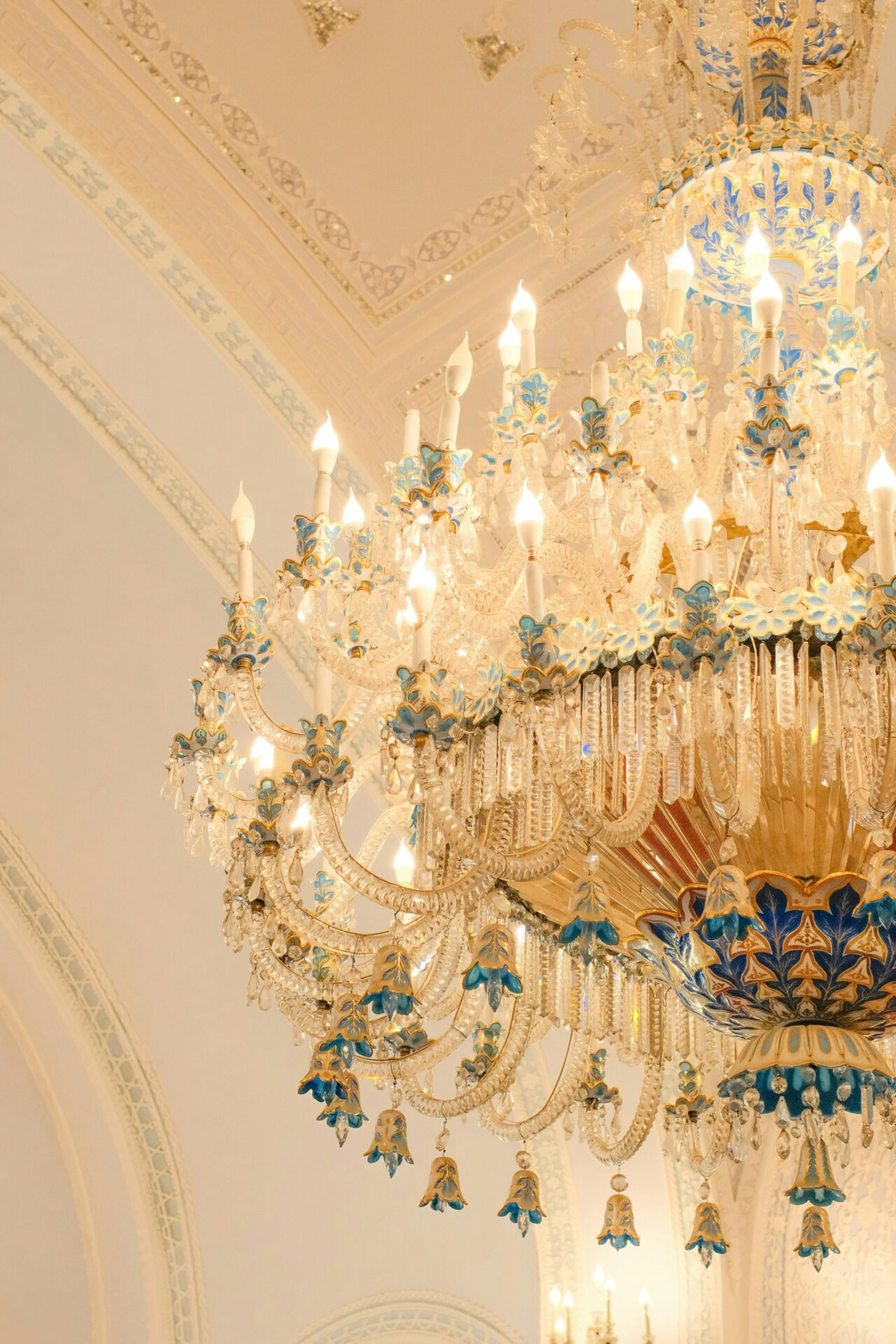 Eleganter Kristallkronleuchter mit blauen und goldenen Akzenten, perfekt für erfolgreiche Frauenräume.