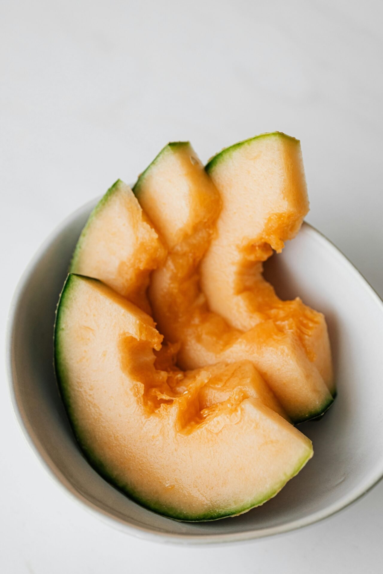 Gesundes Essen für die Arbeit: kalte, geschnittene Cantaloupe-Melone in einer weißen Schale.