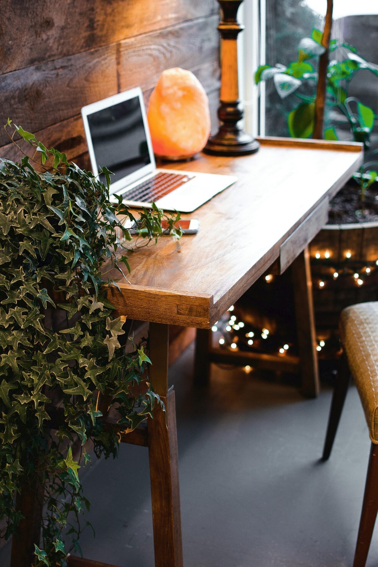 Holzschreibtisch mit Laptop, Salzlampe, Pflanze – perfekt für Familie und Karriere am Fenster.