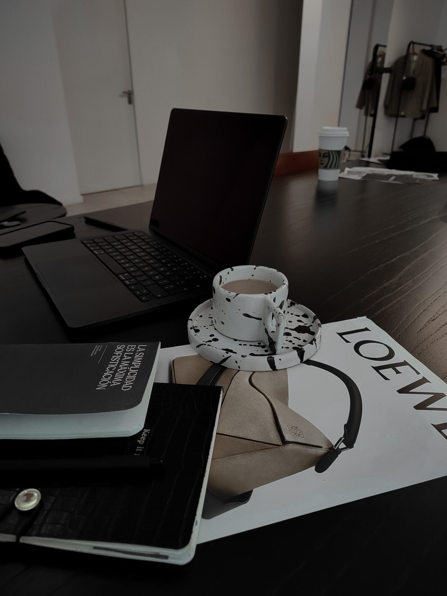 Eine gesprenkelte Tasse, ein Laptop, Notizbücher und ein LOEWE-Magazin für Suchende nach finanzieller Freiheit.