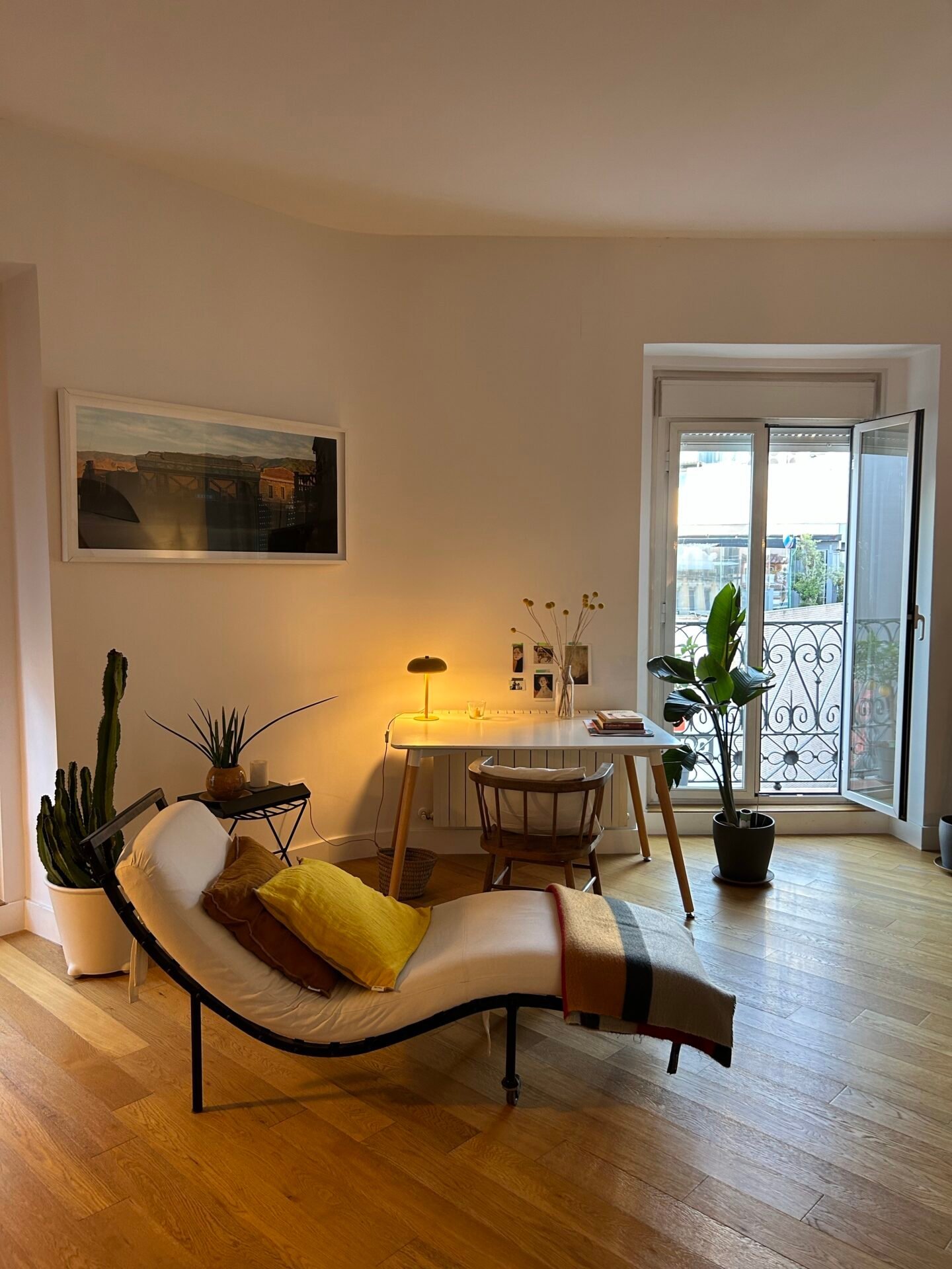 Ein gemütliches Zimmer mit Loungesessel, kleinem Schreibtisch, Pflanzen und Balkon – ideal für finanzielle Freiheit.