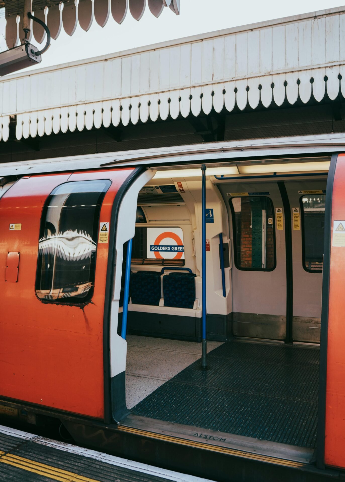 Offene Zugtüren der Londoner U-Bahn am Bahnhof Golders Green mit leeren Sitzen in London sichtbar.