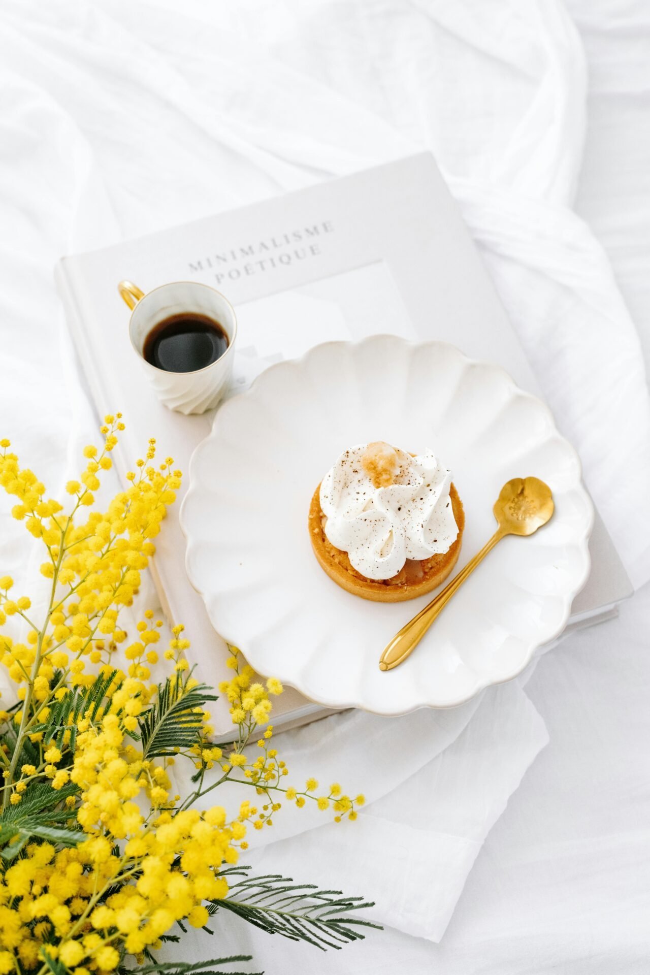 Tasse Kaffee, Dessert mit Sahne, goldener Löffel – perfekt für einen Mentalitätswechsel auf weißem Hintergrund.