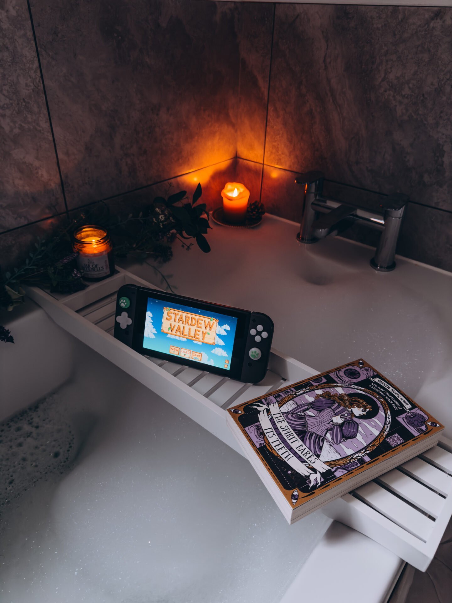 Auf einem Badewannentablett finden ein Buch, Kerzen und ein Nintendo Switch Platz – perfekt für Online-Business-Pausen.