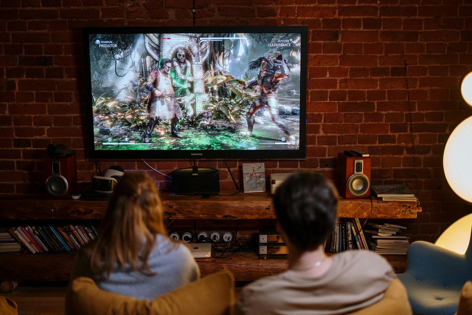 Zwei Personen entspannen sich nach einem langen Tag voller Online-Geschäfte auf einem Sofa und spielen ein Kampfspiel.