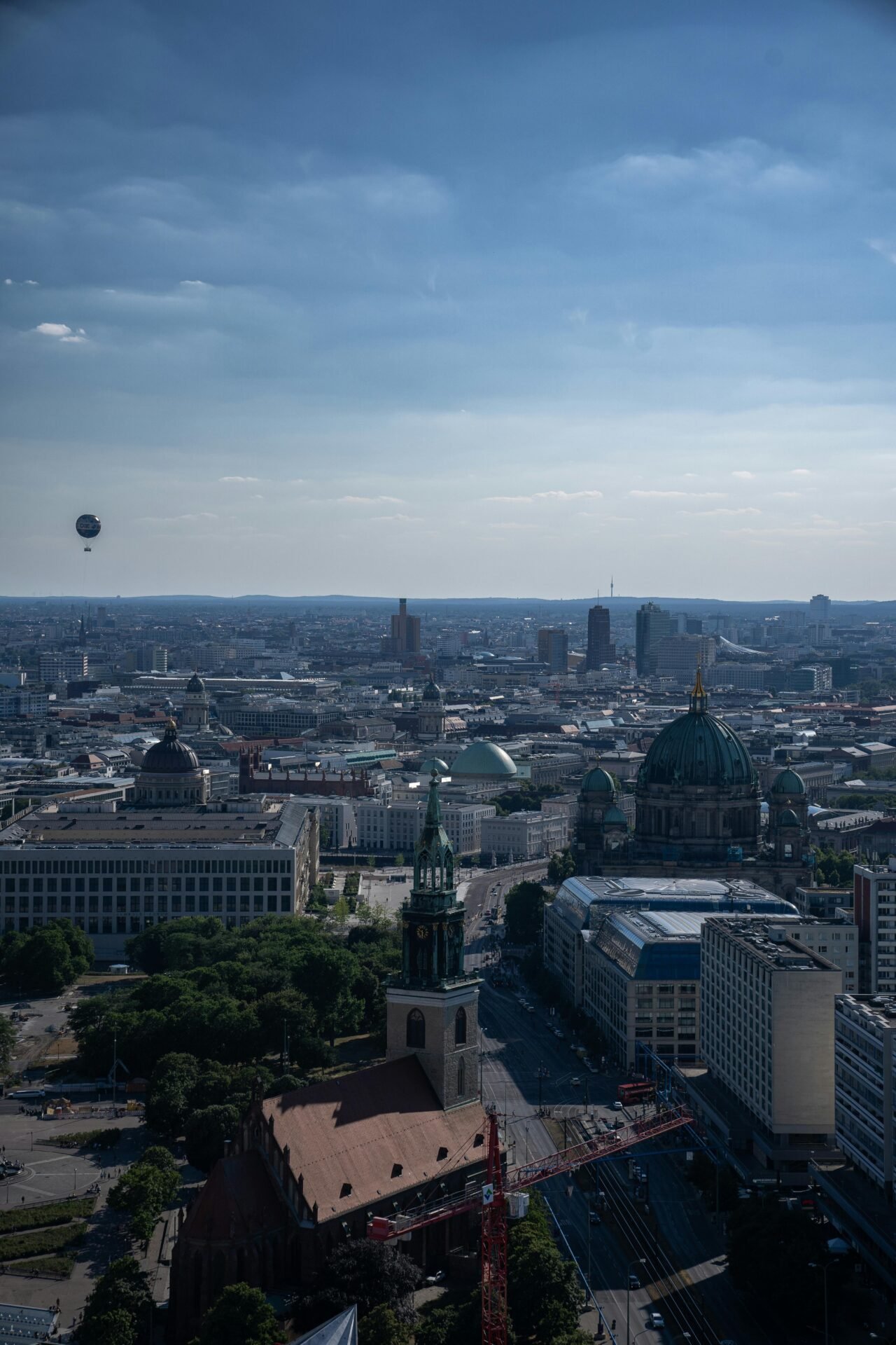 Luftaufnahme der Berliner Sehenswürdigkeiten mit historischen Kuppelbauten unter blauem Himmel.