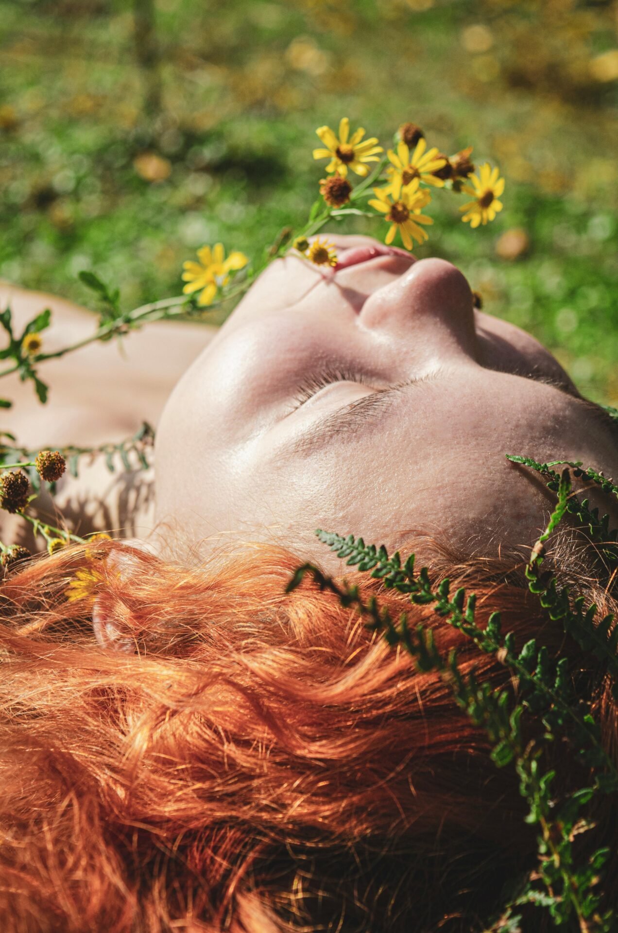 Ein rothaariges Mädchen, vielleicht Pippi Langstrumpf, liegt auf einer Wiesen mit gelben Blumen und genießt die Sonne.