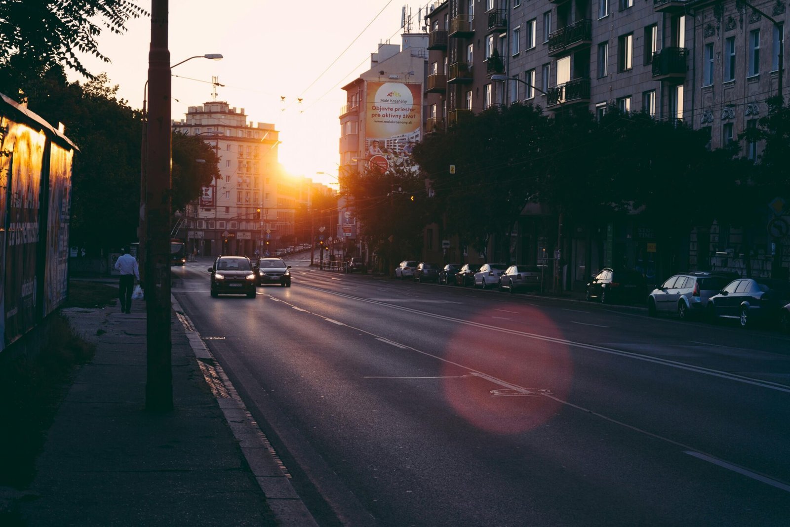 Autos fahren bei Sonnenuntergang auf einer Stadtstraße und spiegeln die Ruhe einer 5-Uhr-Morgenroutine wider.