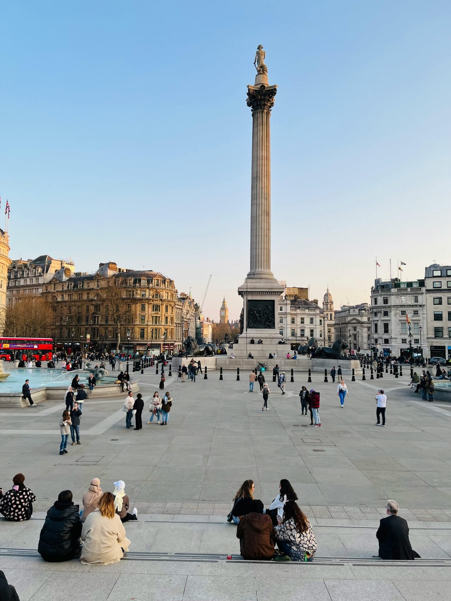 Menschen versammeln sich auf dem Trafalgar Square in London, in dessen Mitte die Nelson-Säule steht.